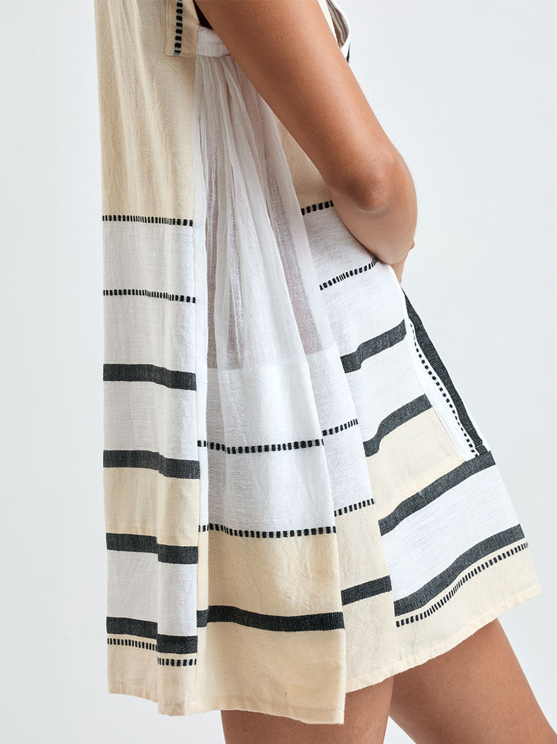 Close up on a  Woman standing wearing lemlem handwoven ELINA Caftan featuring  refined palette of crisp white, soft cream, and deep black