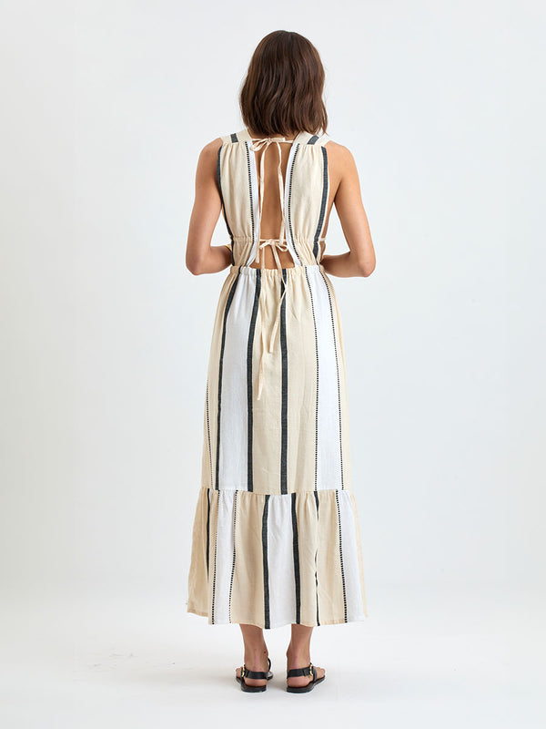 Back of a Woman standing wearing lemlem handwoven LELISA Dress featuring  refined palette of crisp white, soft cream, and deep black