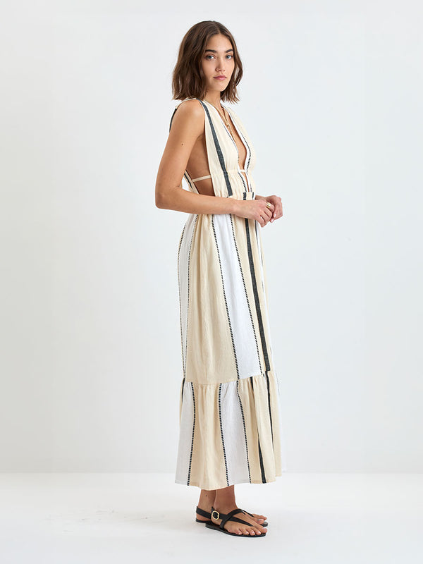 Woman standing wearing lemlem handwoven LELISA Dress featuring  refined palette of crisp white, soft cream, and deep black