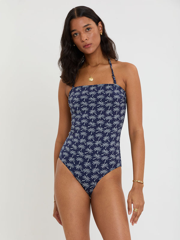 Woman Standing Wearing lemlem DINHA One Piece featuring ivory palm tree motifs set against a rich navy background