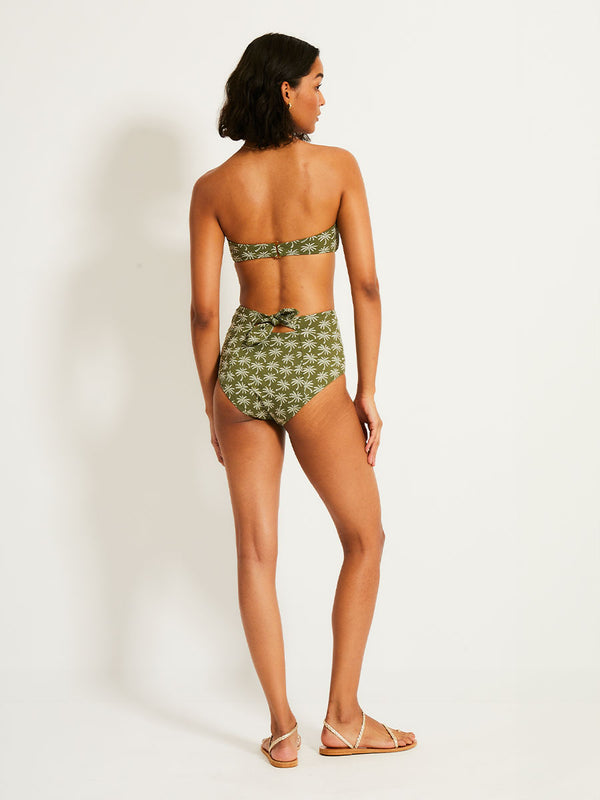 Back of a Woman Standing Wearing lemlem AVA Bandeau Top eaturing  jacquard fabric adorned with custom-designed knitted palm trees and matching high waist bottom