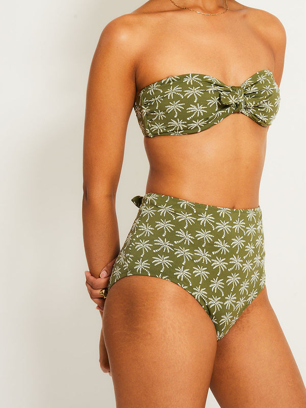 Close up on a Woman Standing Wearing lemlem AVA Bandeau Top eaturing  jacquard fabric adorned with custom-designed knitted palm trees and matching high waist bottom