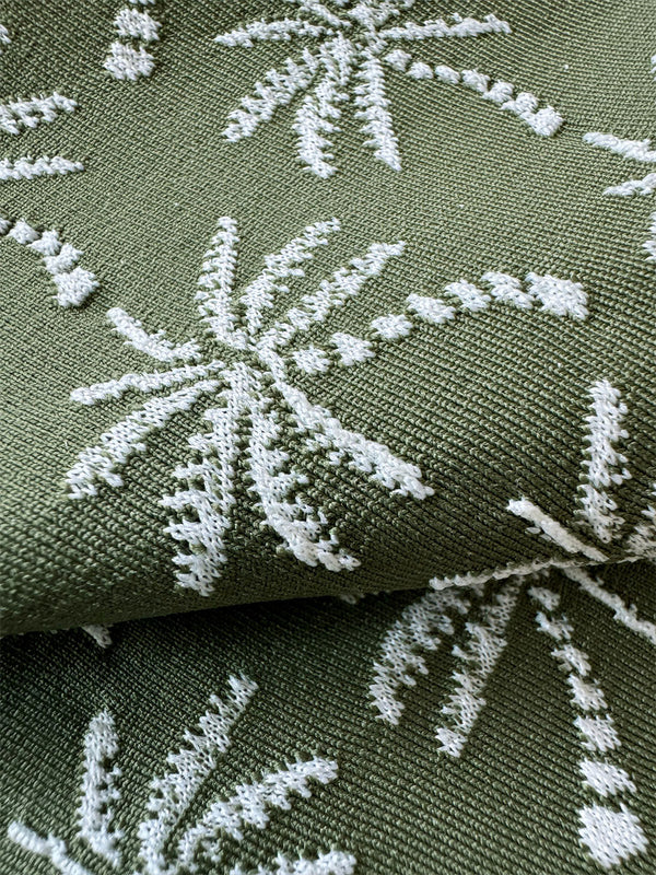 close up on lemlem Zafi Olive fabric featuring  jacquard fabric adorned with custom-designed knitted palm trees