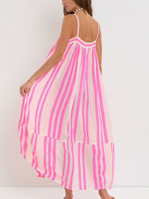 Woman Standing wearing lemlem handwoven EDA Slip Dress featuring a ribbon stripe pattern with a picot edge in vibrant neon pink on a soft vanilla background 