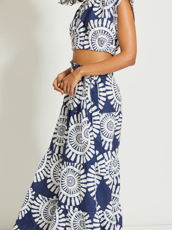 Close up on a Woman Standing Wearing lemlem SANAA | Skirt Featuring a bold geometric medallion pattern on navy background, inspired by traditional Tibeb motifs.