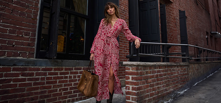 Woman standing wearing lemlem ANIKA Sundress featuring white floral pattern on red background