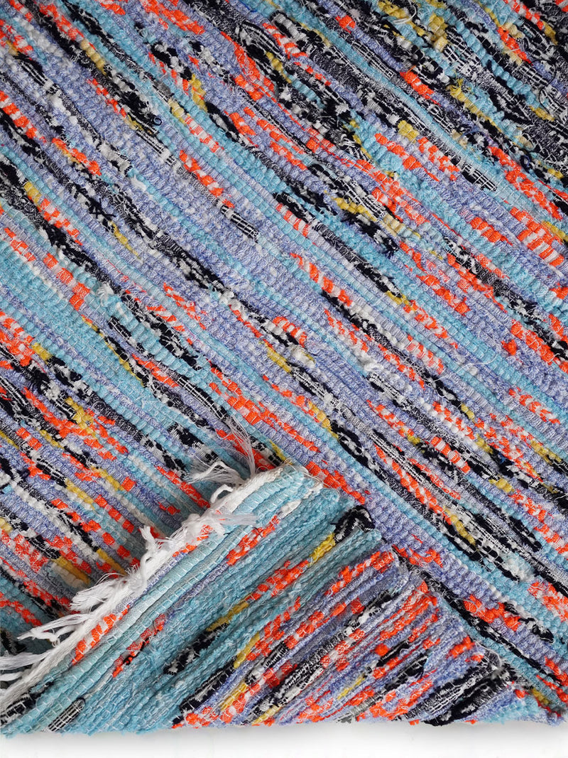 Close Up Shot of a folded Blue & Pink Rug featuring Orange, Blue and Black Colors