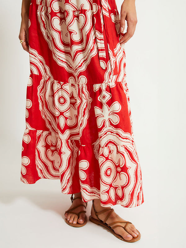 Close up on Woman's legs Standing Wearing  lemlem Crop Top and Skirt featuring custom-designed print inspired by ancient architectural patterns in rich, vibrant red and creamy ivory colors