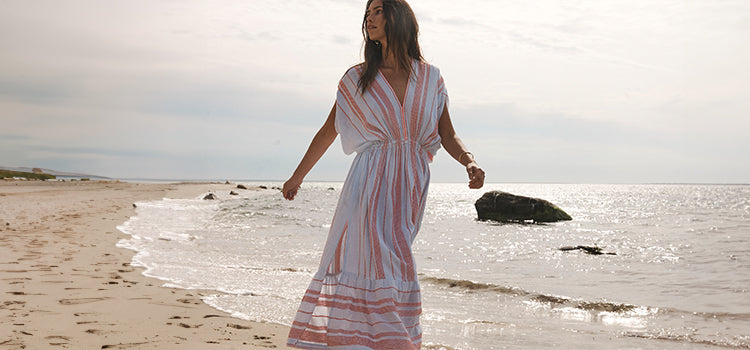 Woman Walking on the beach wearing lemlem tiki skypop plunge dress