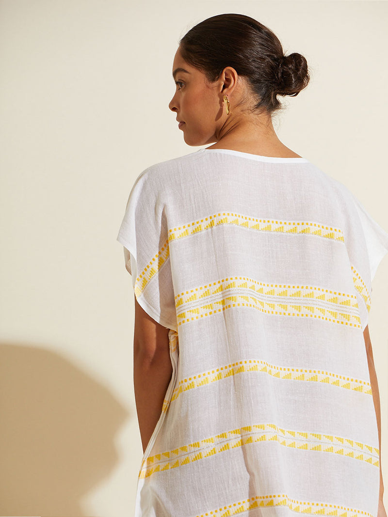 Back view of a woman wearing the Abeba Classic Caftan featuring the yellow signature Tibeb pattern and gold lurex highlights on a white background.