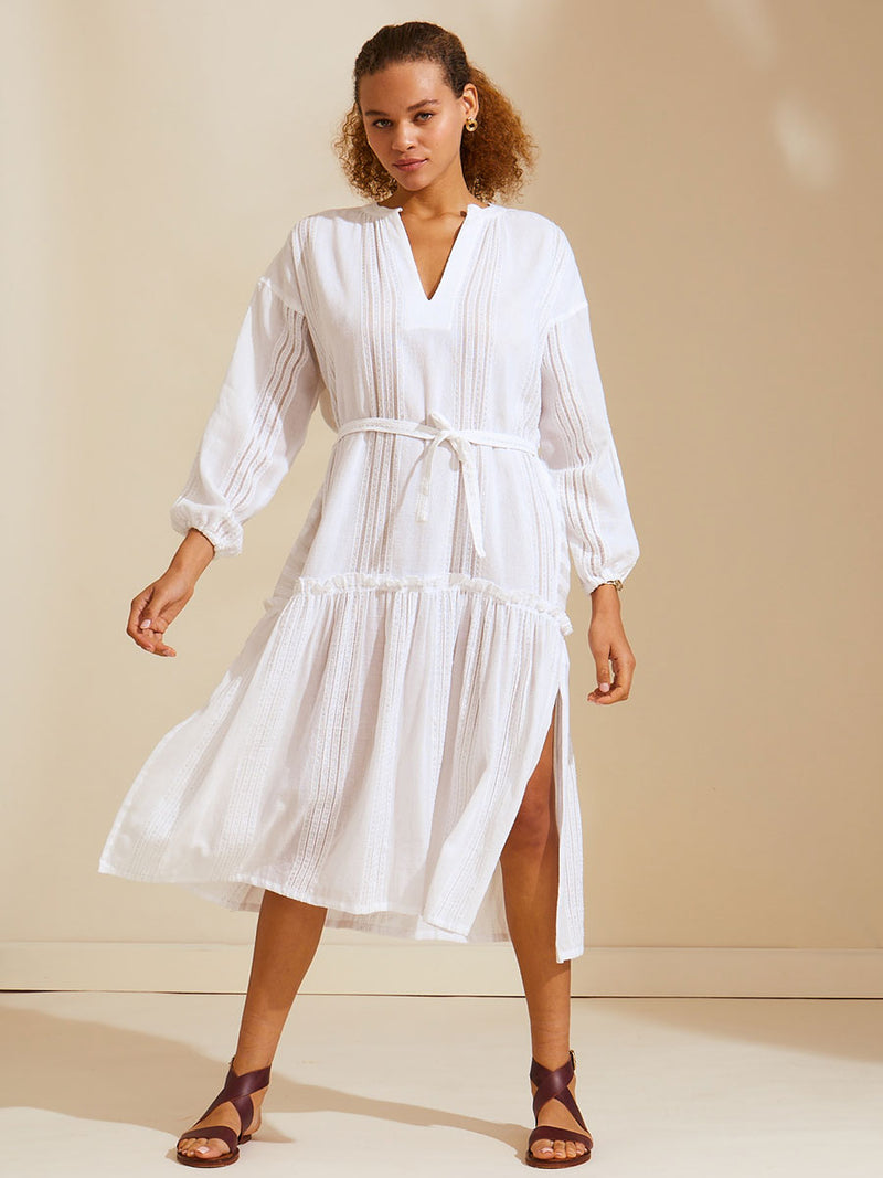 Woman standing wearing a white Abira Poet Shirt Dress with stitches of silver lurex
