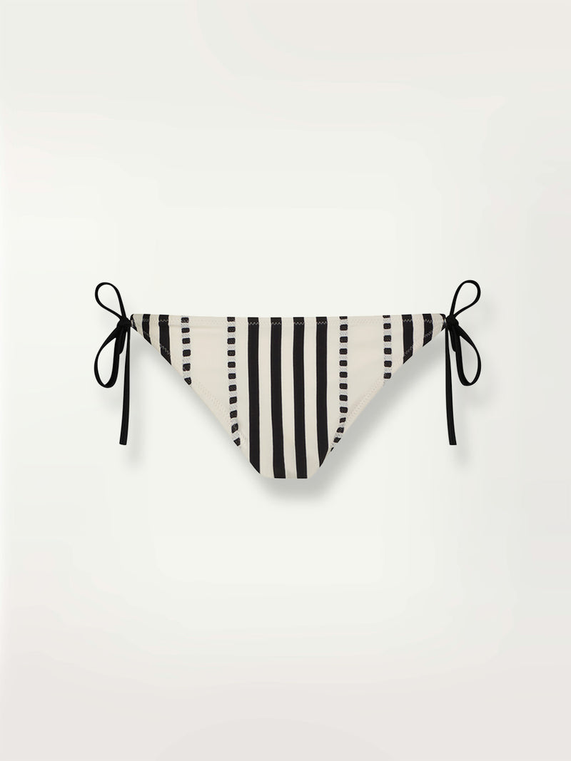 Product shot of the Eshe String Bikini Bottom and matching triangle top featuring architectural and textured black stripes and dotted lines on an off white background.