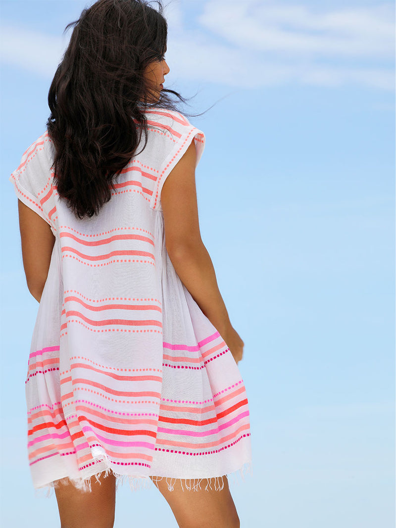Back view of a woman standing wearing the Eshe Caftan Dress in pink featuring pink stripes and dots pattern.