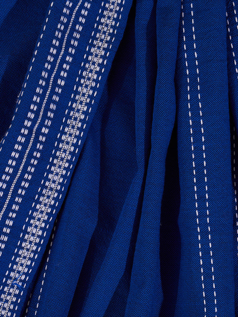 Close up on the fabric of the Inku Short Plunge Neck Dress featuring textured white dots on deep blue background.