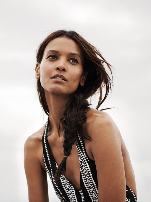 close up of a woman wearing a black graphic diamond and arrows deep v one piece outside