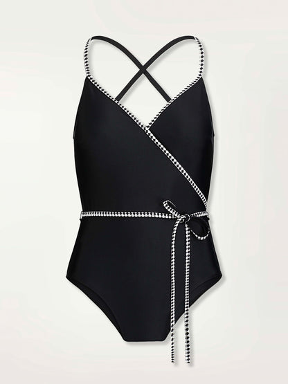 Product shot of the front of the Lena Ballet One Piece in Black featuring a black and white tibeb trim and waist tie.