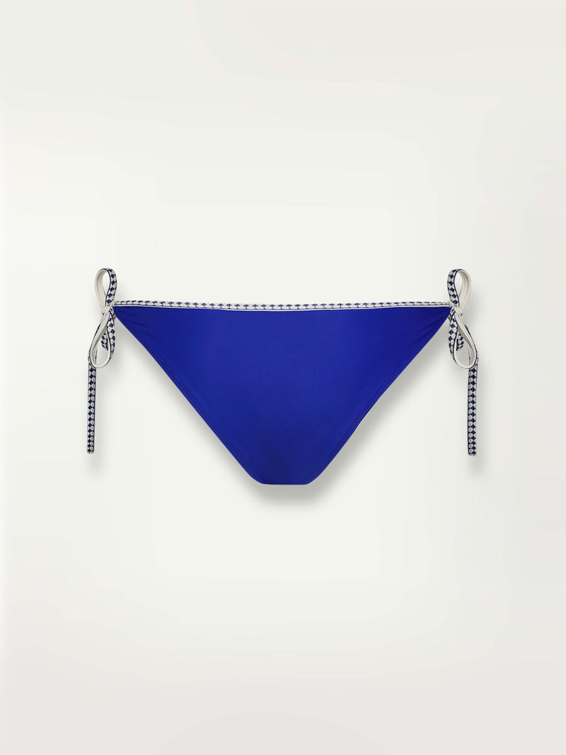 Product shot of the back the Lena String Bikini Bottom  in bright neon blue adorned with navy and white diamond jacquard pattern on the trims