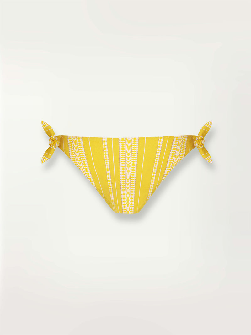 Product shot of the Luchia Side Tie Bikini Bottom in yellow and enhanced with ivory and strands of golden shimmering lurex.