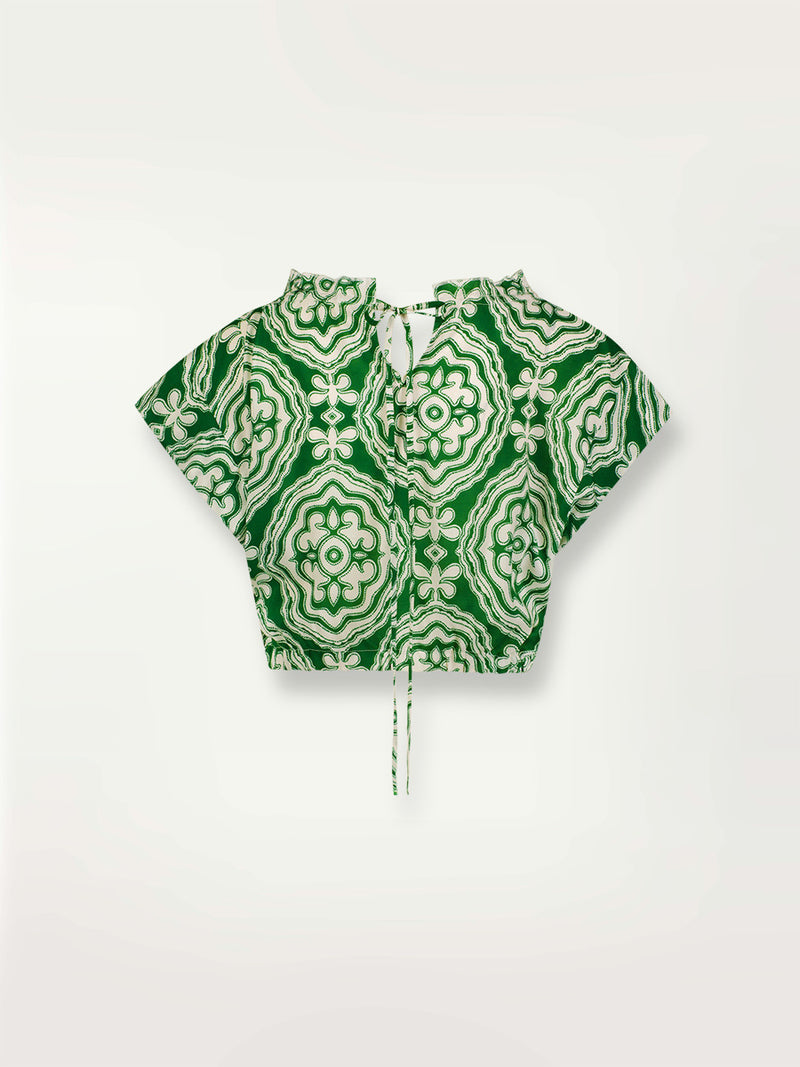 Product shot of the back the Medallion Ruched Crop Top featuring architectural white patterns on a deep green background.