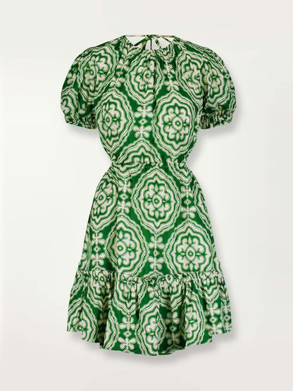 Product shot of the Medallion Short Open Back Dress featuring architectural white patterns on a deep green background.