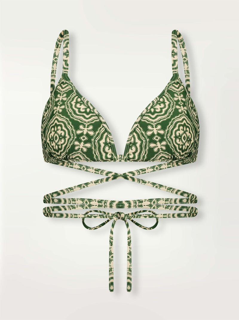 Product shot of the Medallion Wrap Triangle Top featuring architectural white patterns on a deep green background.
