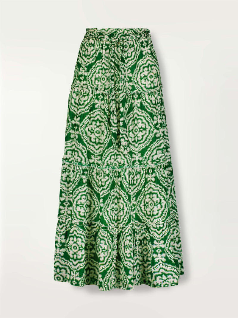 Product shot of the Medallion Maxi Skirt featuring architectural white patterns on a deep green background.