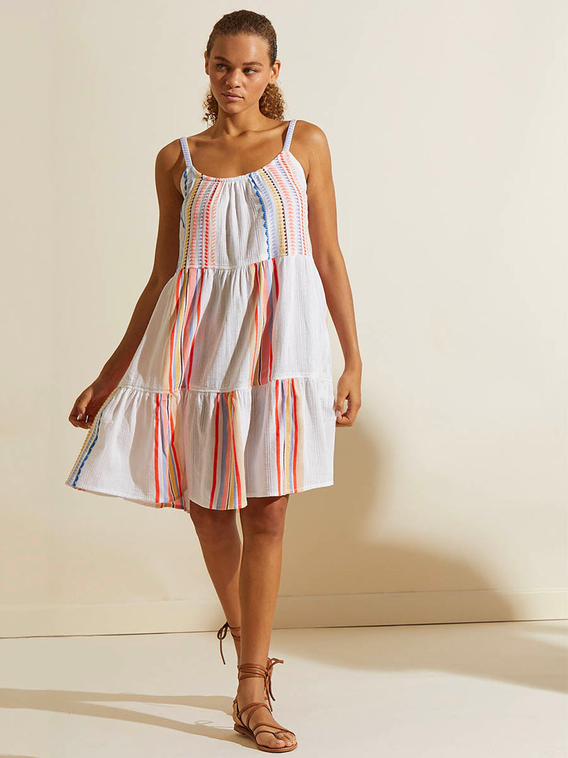 Woman standing wearing the Bekah Midi Cascade Dress featuring 10 tutti frutti colors embroidered on a white background.  