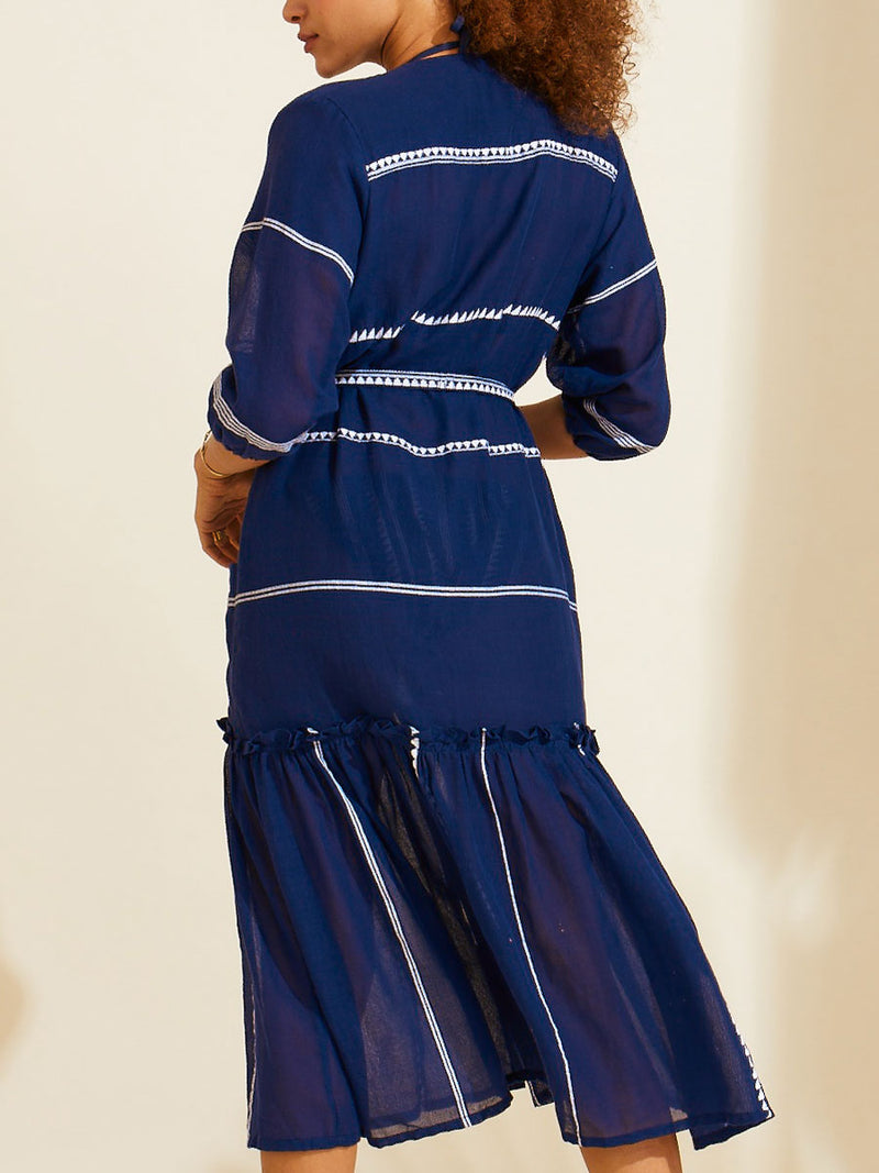 Back view of a woman standing wearing a navy with white stripes and graphics long robe