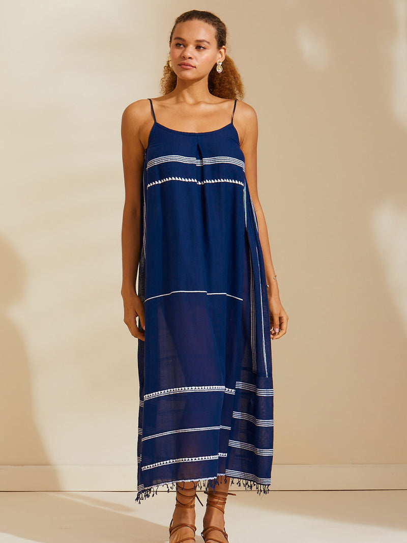 Woman standing wearing the Nunu Long Slip Dress in navy blue featuring white stripes and graphic lines.