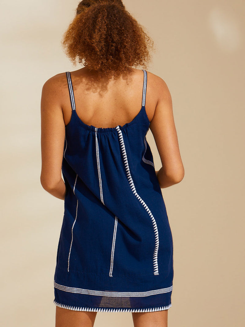 Back view of a woman wearing a navy with white stripes and graphics swing dress