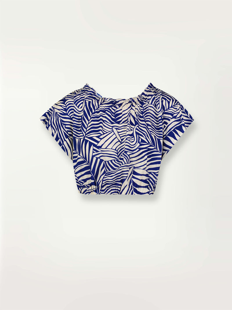 Product shot of the Palm Leaf Ruched Crop Top featuring palm tree patterns on a rich blue background.