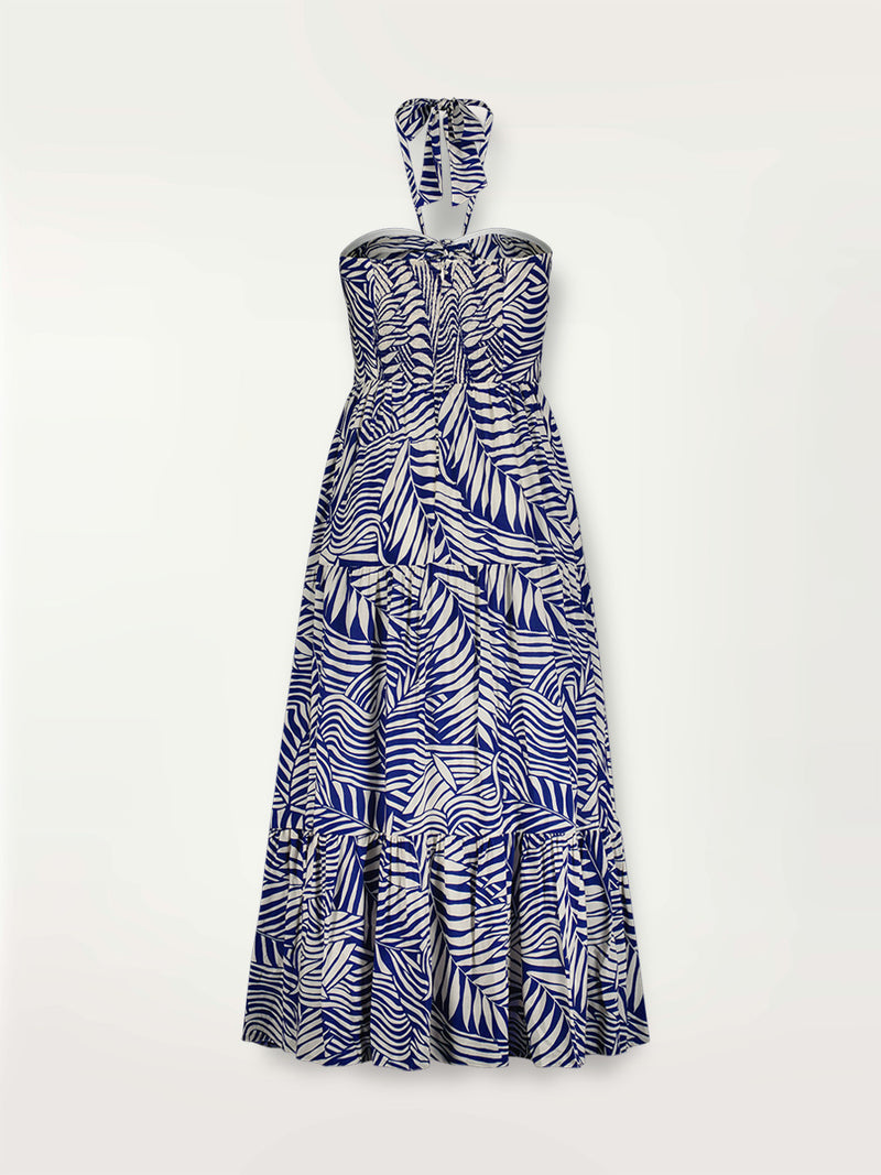 Product shot of the back the Palm Leaf Cutout Dress featuring palm tree patterns on a rich blue background.