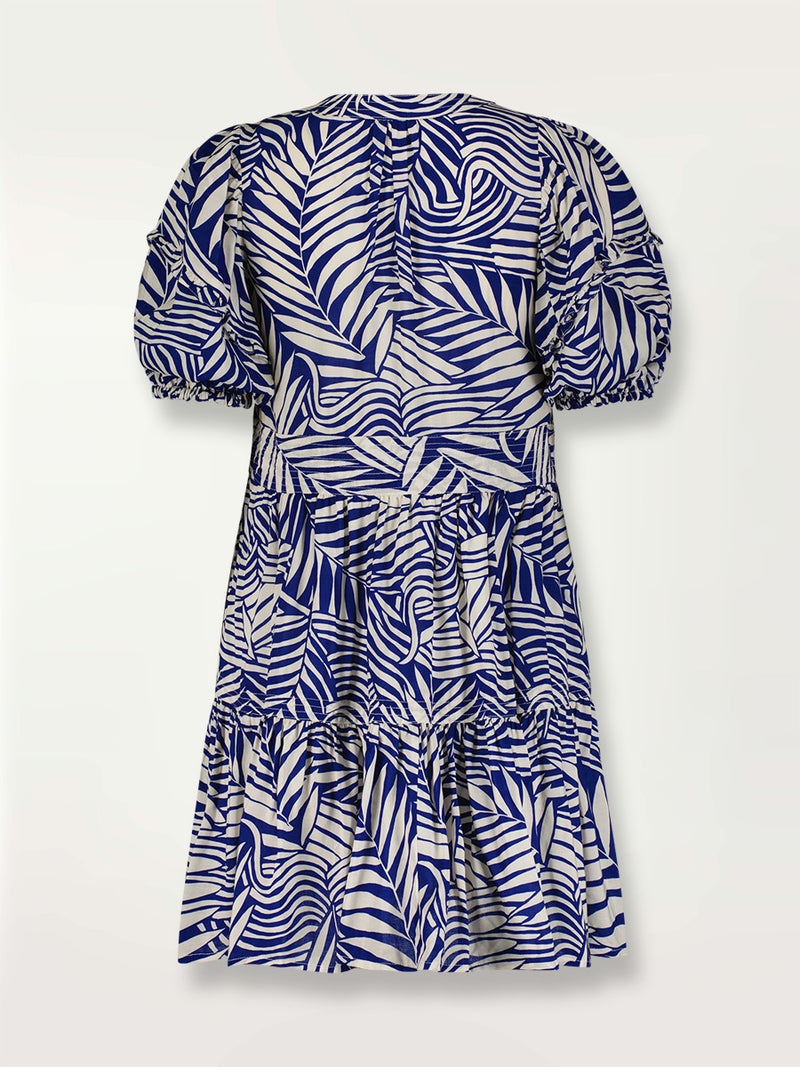 Product shot of the back the Palm Leaf Flutter Sleve Mini Dress featuring palm tree patterns on a rich blue background.