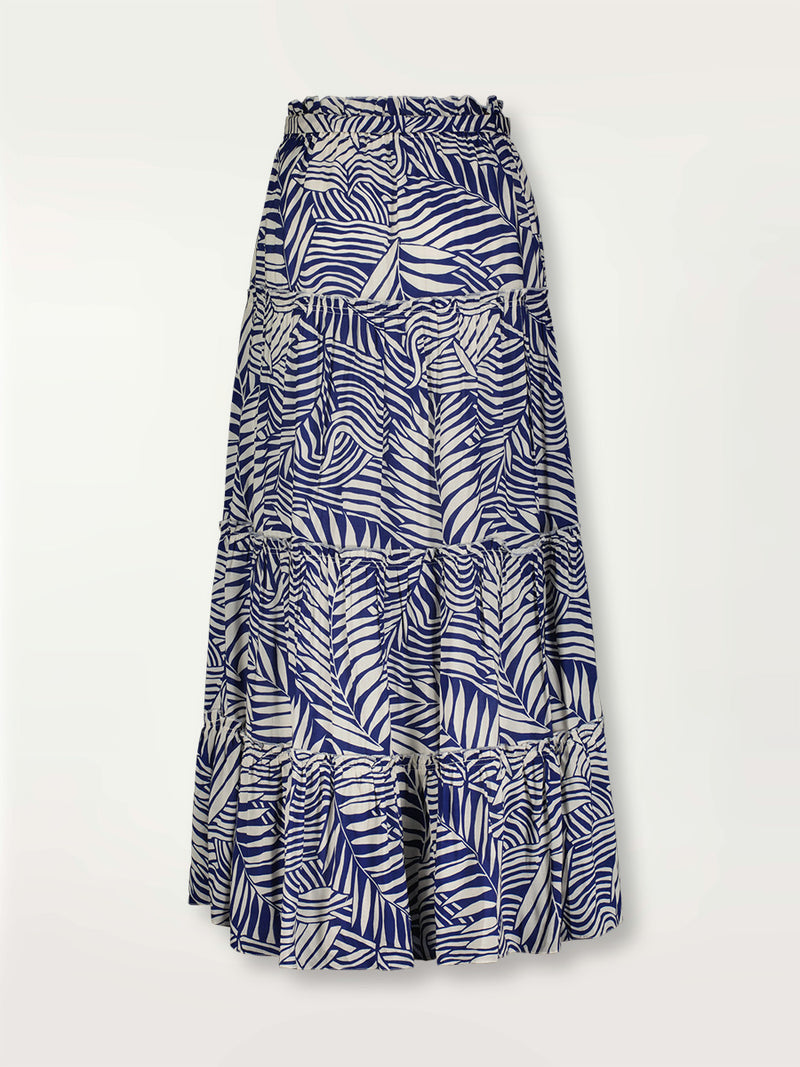 Product shot of the back the Palm Leaf Maxi Skirt featuring palm tree patterns on a rich blue background.