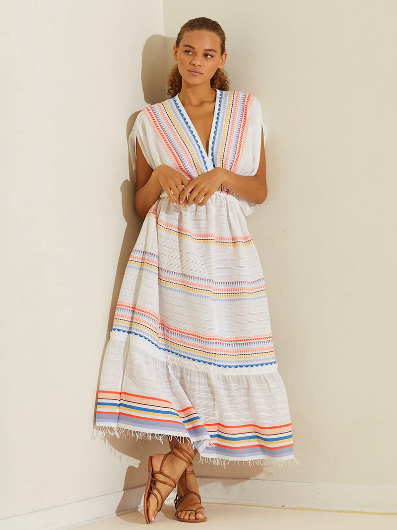 Woman standing wearing the Bekah Plunge Neck Dress featuring 10 tutti frutti colors embroidered on a white background.  