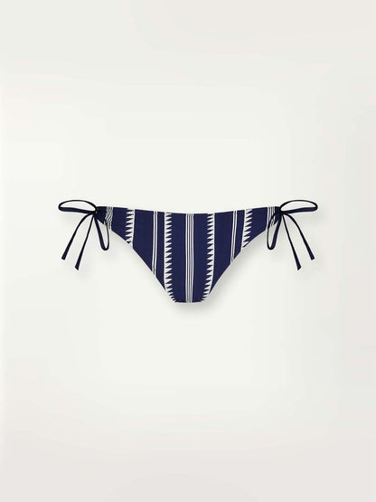 Product-shot navy Nunu string bikini bottom with white triangles and stripes