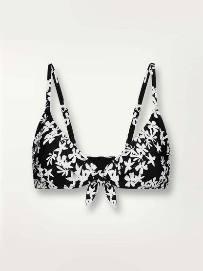 Product-shot of the front of the Sea Floral Tie Front Top in black featuring white allover floral print.