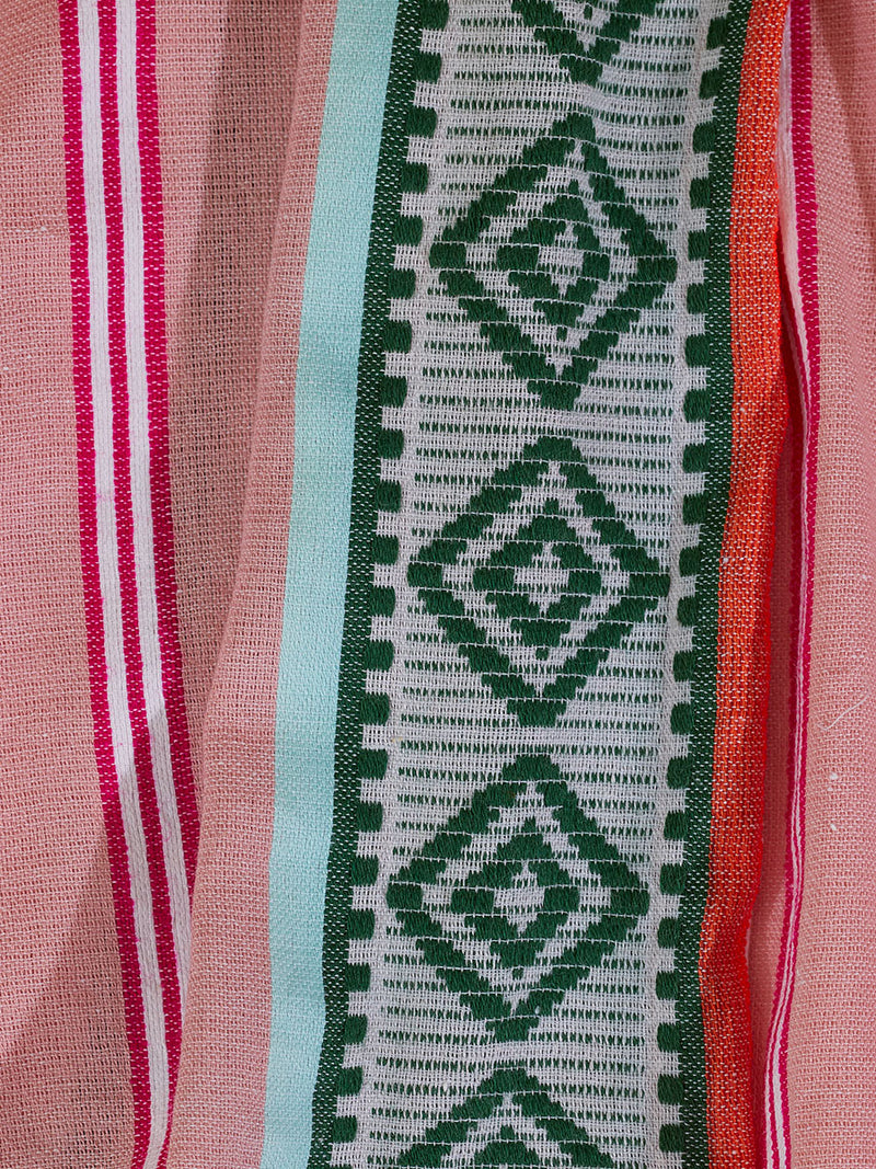 Close up on the fabric of the Rosa Short Plunge Neck Dress featuring architectural details and geometric border patterns woven on a soft pink background.